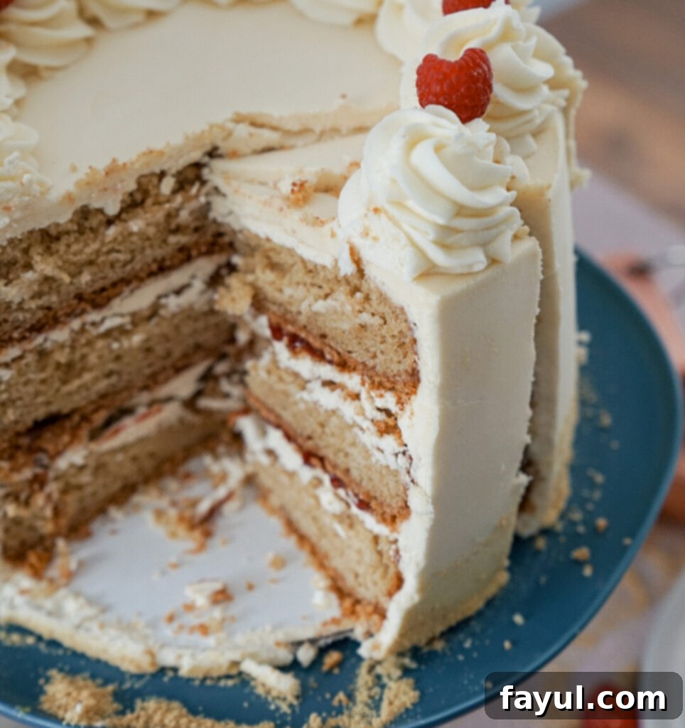 Beautifully decorated ultimate birthday cake with visible layers of graham cracker, raspberry, and cake batter buttercream.
