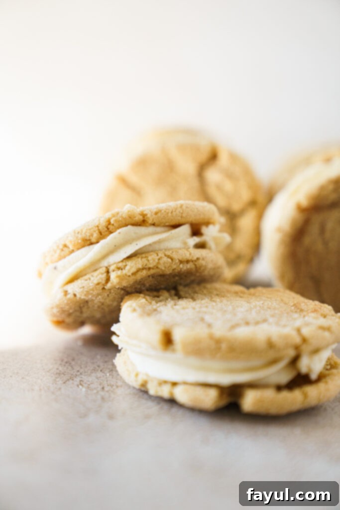 Next-Level Snickerdoodle Cookie Sandwiches 3 Stacked Snickerdoodle Cookie Sandwiches - A pile of finished snickerdoodle cookie sandwiches showcasing their soft texture and generous frosting filling.