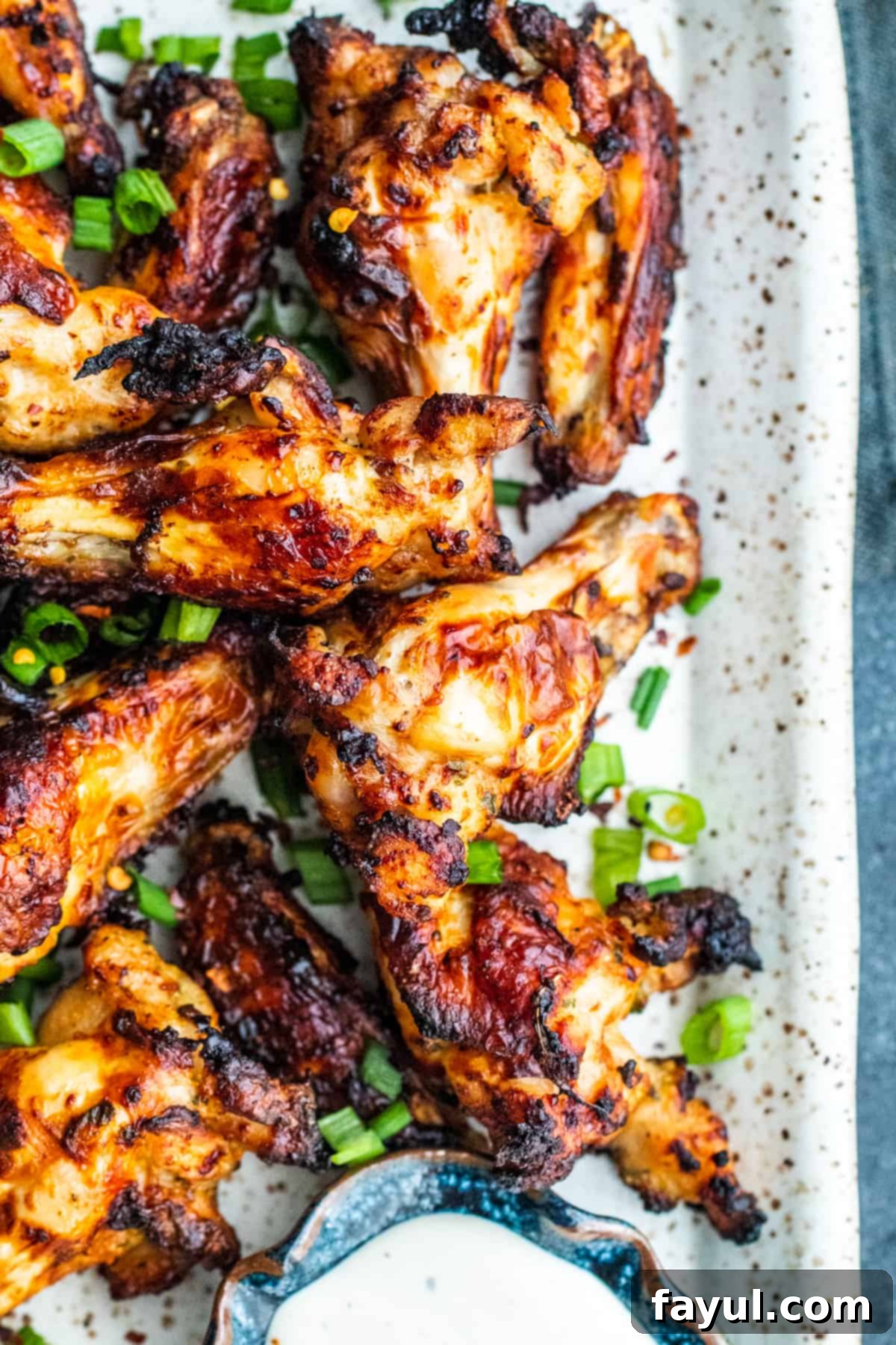 Overhead shot of wings on a white platter with ranch.