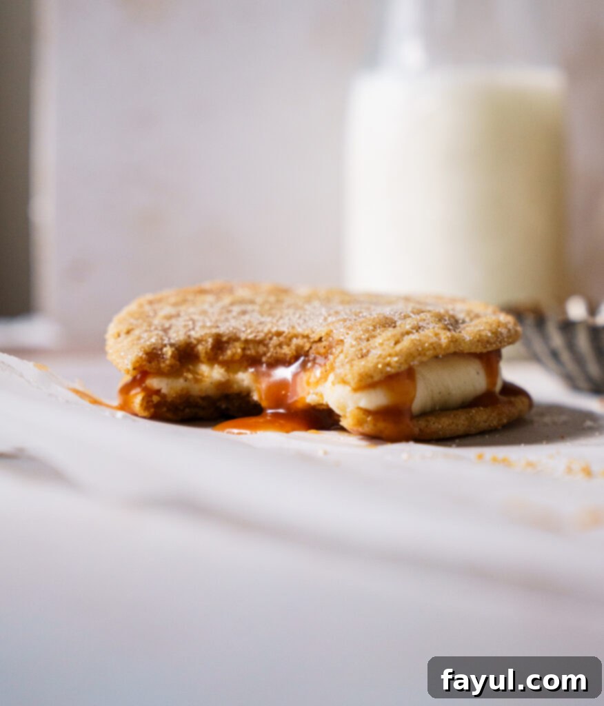 Two halves of a Snickerdoodle Caramel Cookie showing the caramel filling and cream cheese frosting