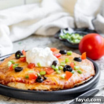 Taco pizza on a black plate shot at angle.