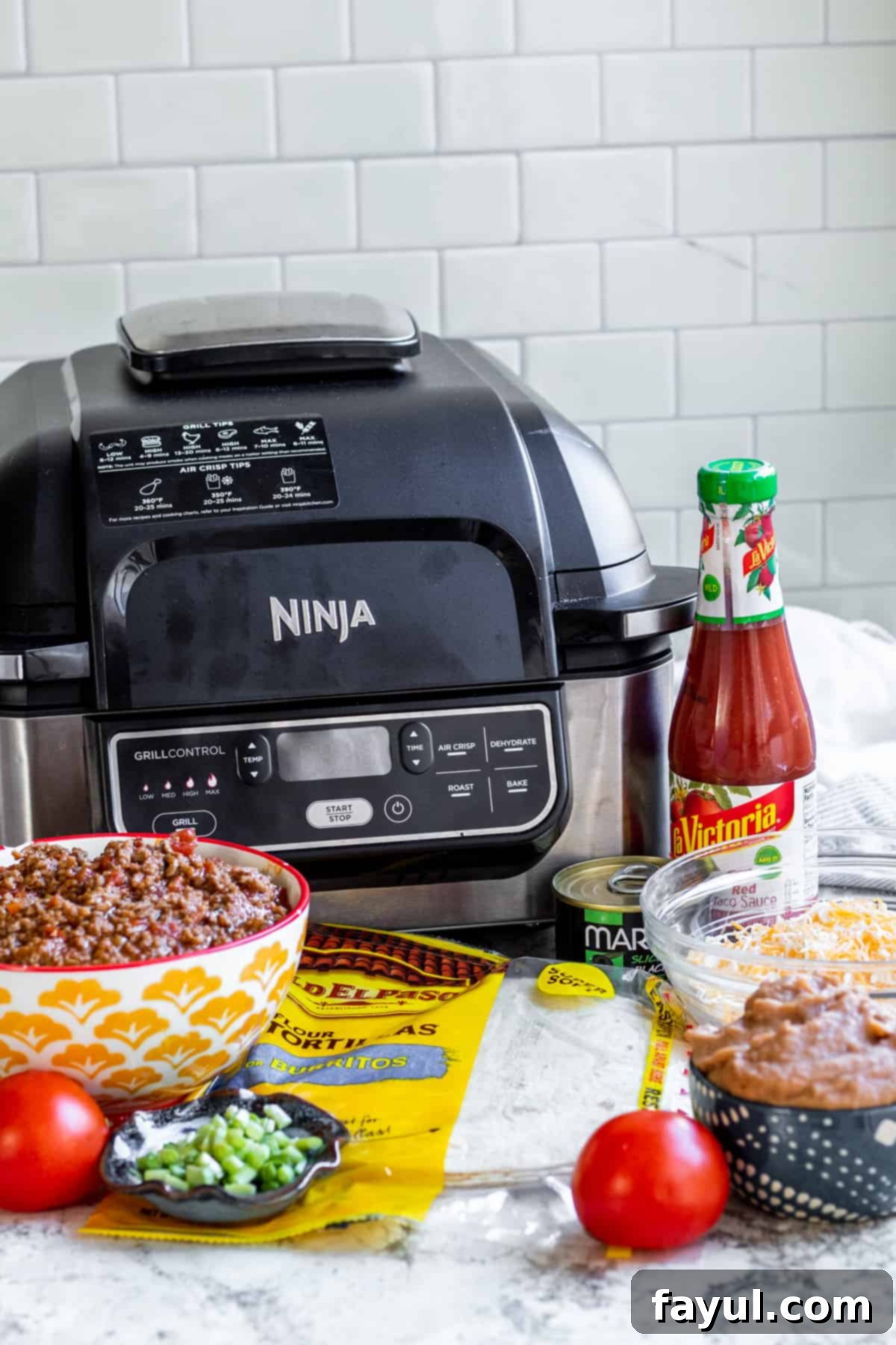 Ingredients for air fryer Mexican pizzas laid out on a white counter in jars and cups.