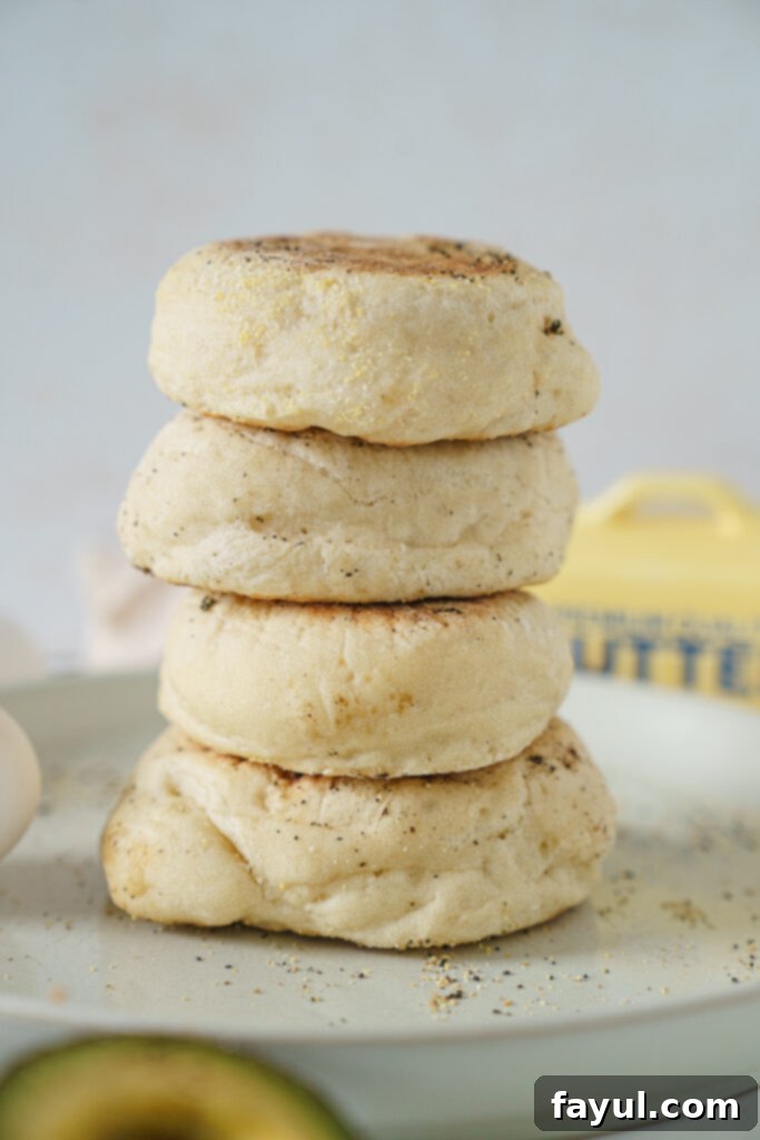 Homemade English muffins cooling on a rack, showing their golden crust and fluffy texture