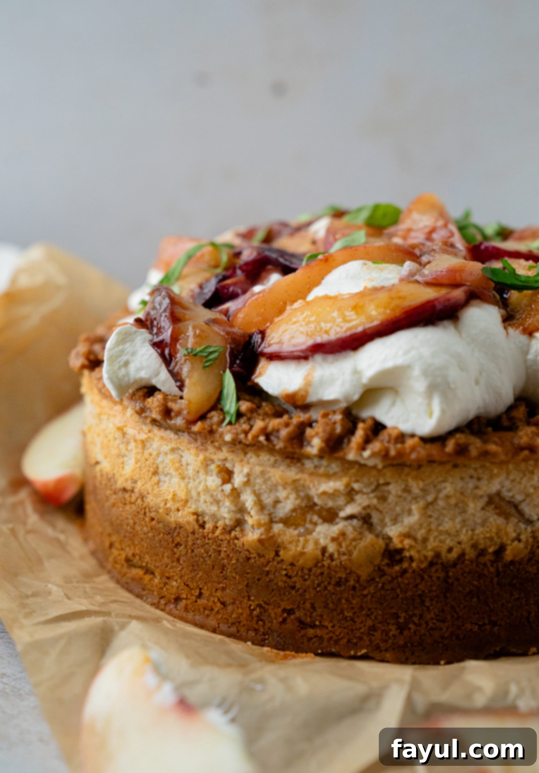 Close-up of the peach cobbler cheesecake with visible layers of crust, cheesecake, and peaches