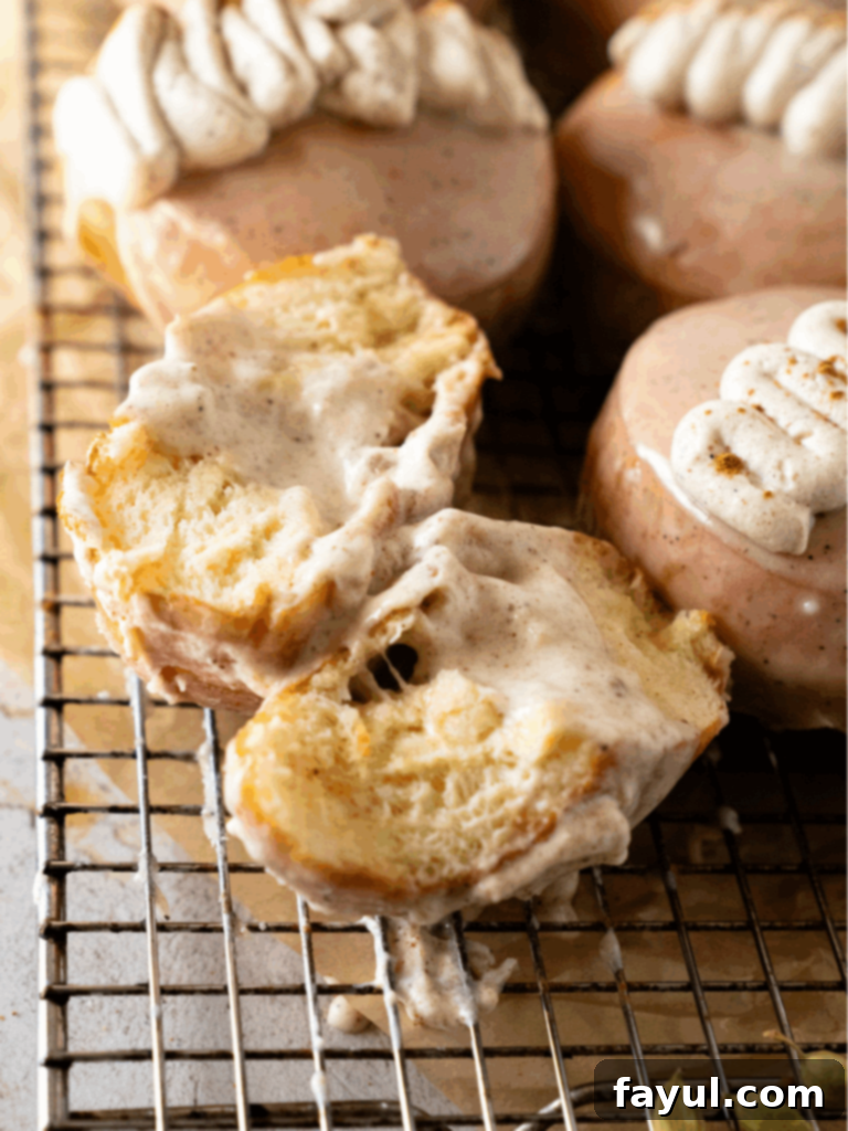 Golden fried chai custard donuts on a wire rack cooling before glazing, showcasing their fluffy texture and perfect browning.