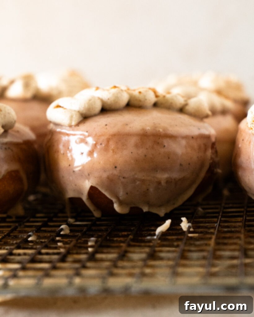Close-up of a chai custard donut cut in half, revealing the abundant, creamy spiced filling and fluffy texture.