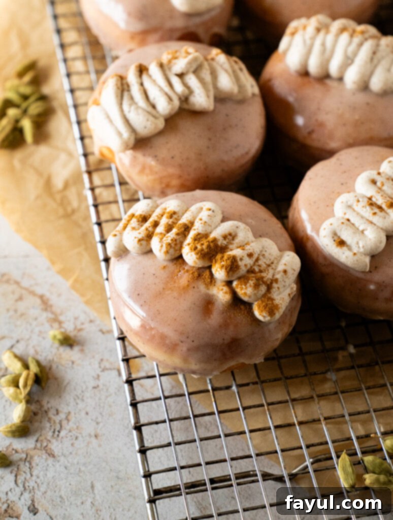 A stack of perfectly fried and glazed chai custard donuts, ready to be enjoyed.