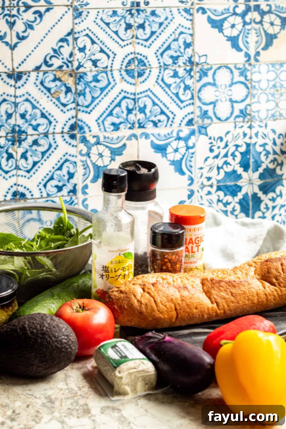 Sandwich ingredients laid out on a white table in bowls and in their original containers with a blue floral background.