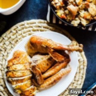 Beautifully cut slices of herb roasted turkey arranged on a pristine white plate, showcasing its juicy texture and golden skin.