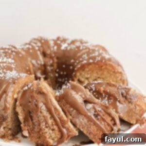Full churro bundt cake, topped with cinnamon sugar and ganache, ready to be served.