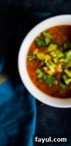 Close up shot of soup in white bowl. Part of bowl is out of frame.