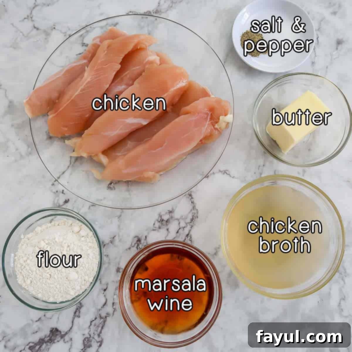 Overhead shot of essential ingredients laid out on a wooden surface: raw chicken tenders, small bowls of salt and pepper, a stick of butter, a bottle of chicken broth, a bottle of Marsala wine, and a bowl of flour.