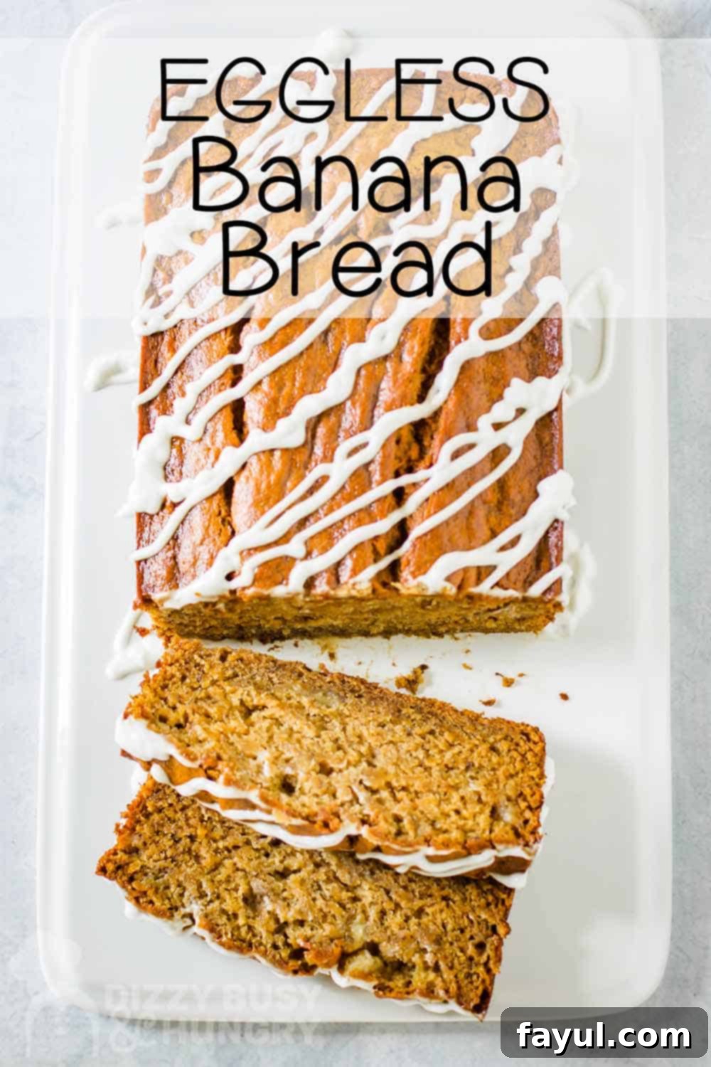 Overhead view of whole eggless banana bread with two slices taken out on a white rectangle plate.