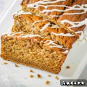 Overhead shot of eggless banana bread in slices on a white rectangle plate.