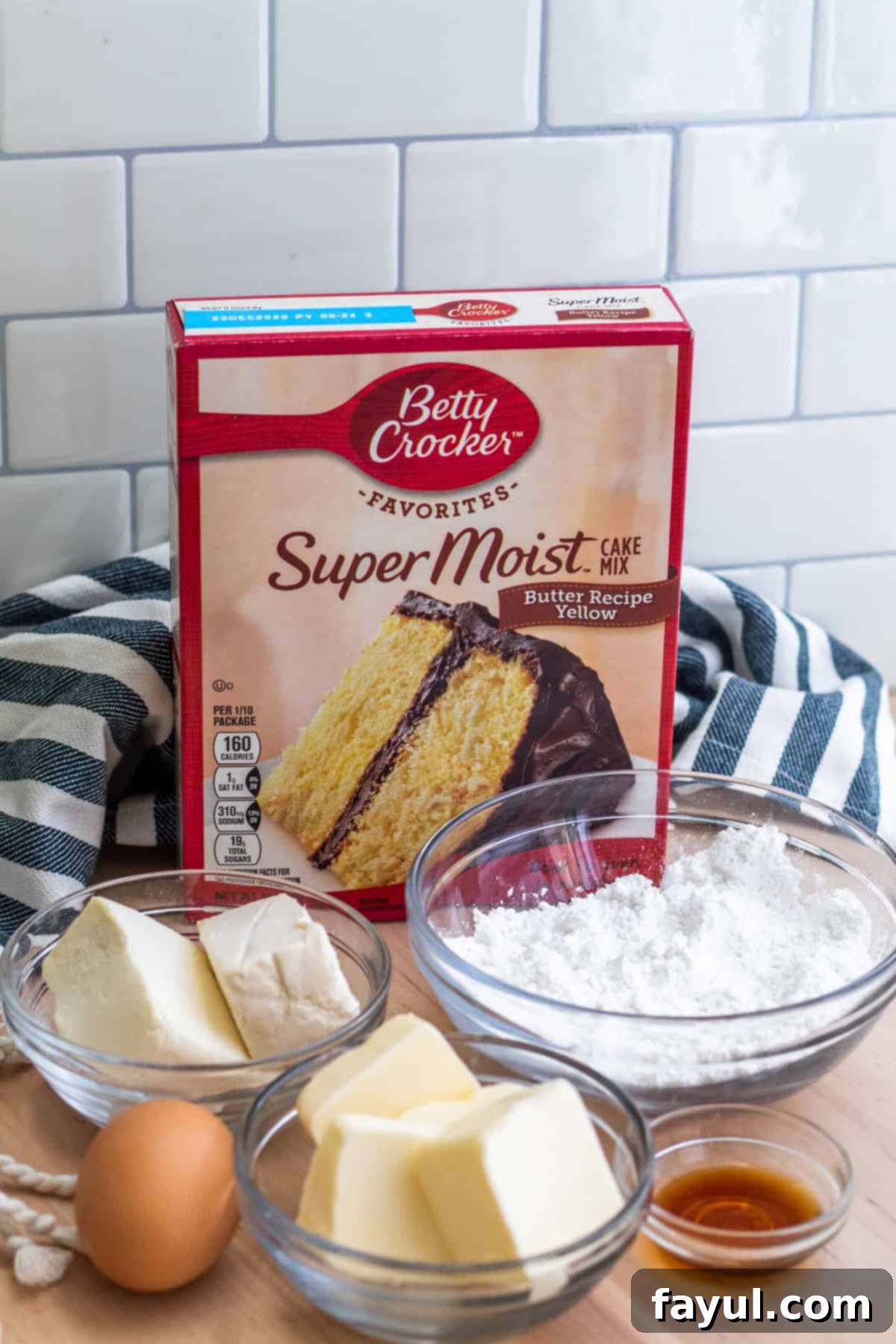 A top-down view of all the essential ingredients for Gooey Butter Cake Cookies, neatly arranged in small white bowls on a rustic wooden table, ready for mixing. Includes a box of yellow cake mix, softened butter and cream cheese, an egg, vanilla extract, and powdered sugar.