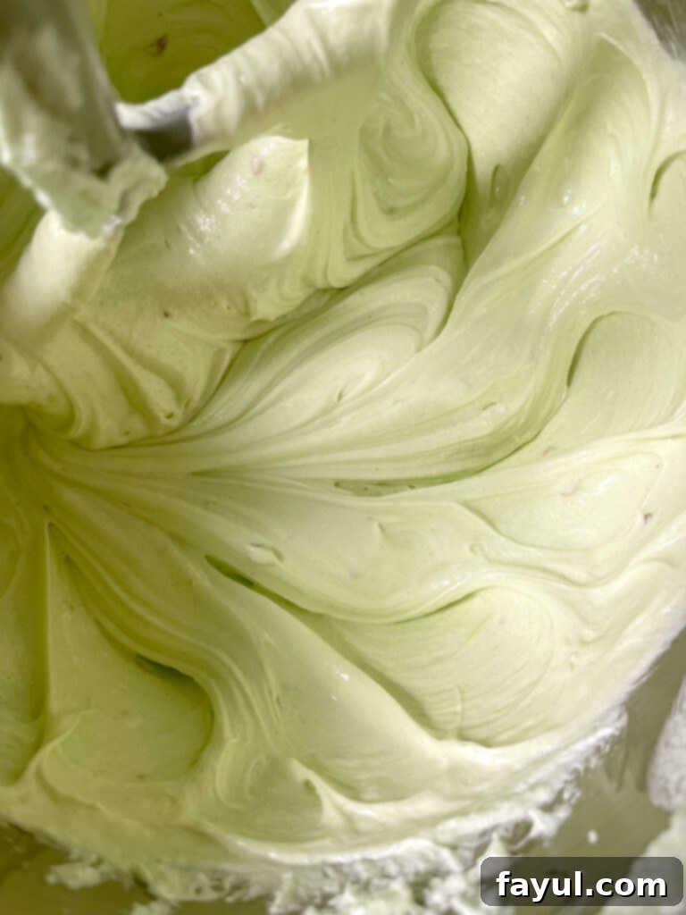 The lemon pistachio bundt cake after being glazed with lemon cream cheese and topped with crushed pistachios, ready to be served.