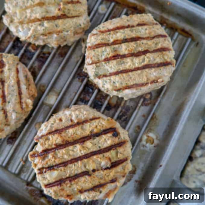 Overhead view of perfectly grilled Thai turkey burgers with attractive grill marks, nearly ready to be served.