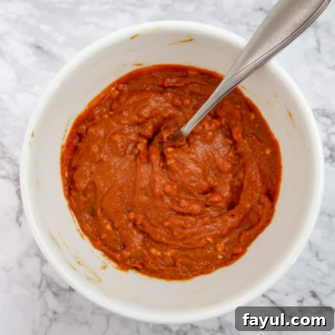 Overhead view of the freshly prepared, smooth peanut sauce in a small white bowl.