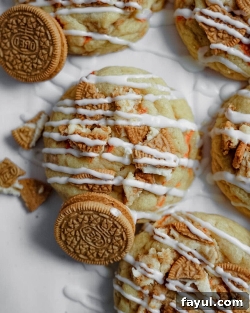 A close-up of a single Carrot Cake Oreo cookie with cream cheese drizzle, on a white plate.