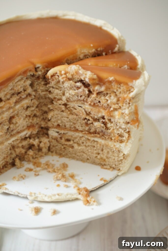Close-up of a beautifully frosted Cinnamon Roll Caramel Cake with caramel drizzle