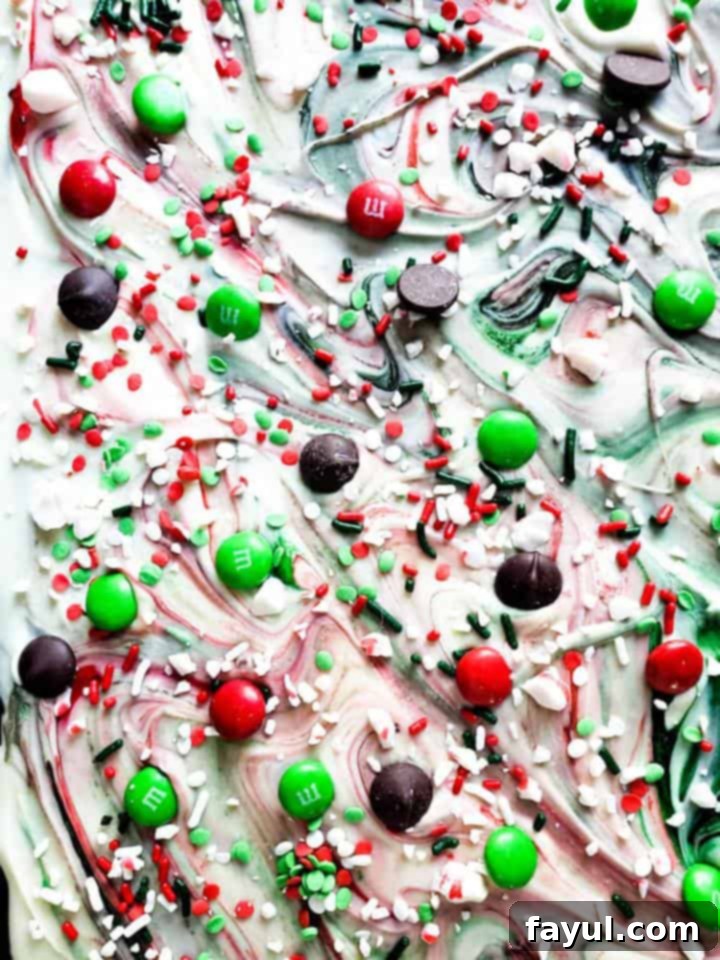 Overhead shot of whole Christmas chocolate bark on a blue counter, showing all the festive toppings.