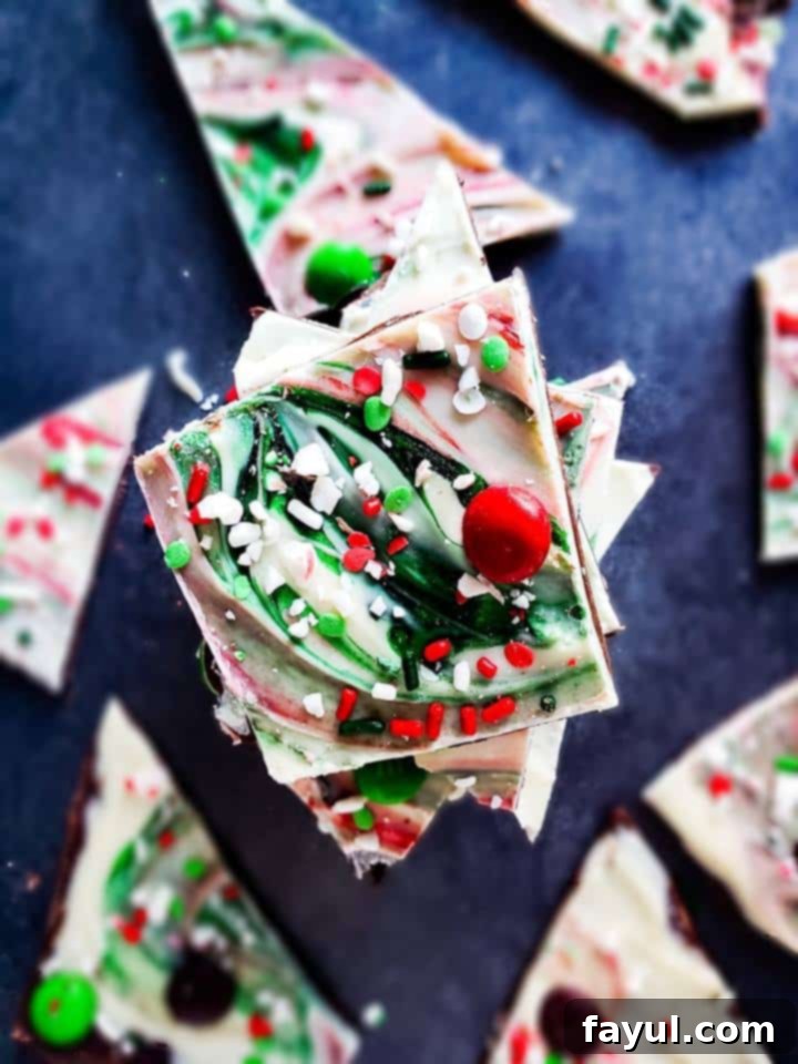 This Christmas Chocolate Bark recipe is perfect for the holiday season! It combines two layers of semi sweet and white chocolate and is topped with peppermint, M&m's and candy. This recipe is easy and makes the best gift for friends, family or to keep for yourself. #Christmas #Homemade #Gift #Chocolate #Recipe