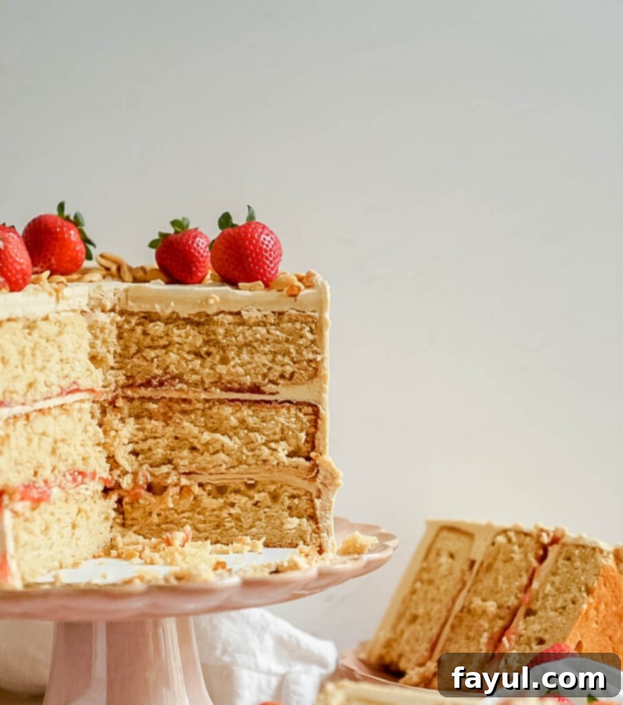 Close-up of a slice of Peanut Butter and Jelly Cake, showing the distinct layers of cake, jam, and frosting.