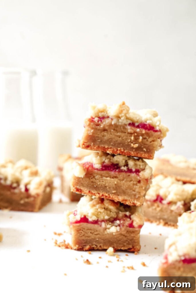 Freshly baked Peanut Butter and Jelly Bars cooling in a parchment-lined baking pan, ready to be sliced.