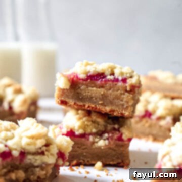 A stack of perfectly cut Peanut Butter and Jelly Bars on a white plate, ready to be enjoyed.