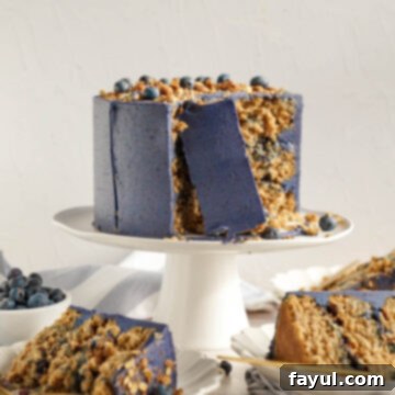 A slice of Blueberry Crisp Cake with fresh blueberries on top