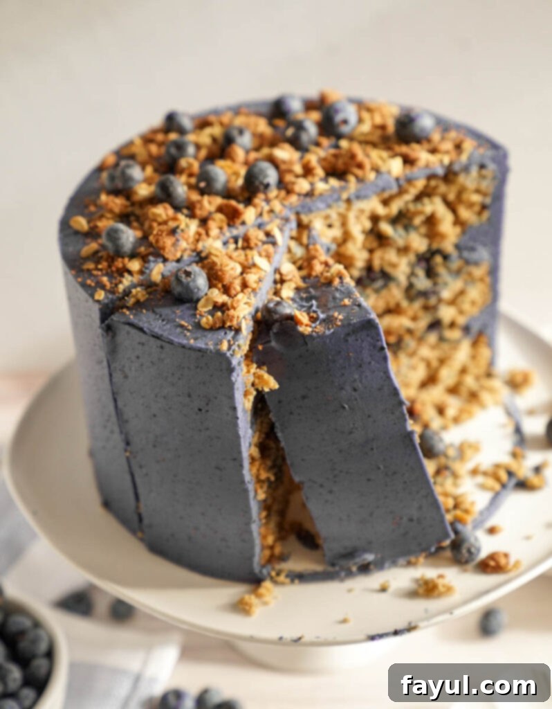 Assembling a layer cake, showing the process of spreading blueberry compote and sprinkling oat crumble between cake layers.
