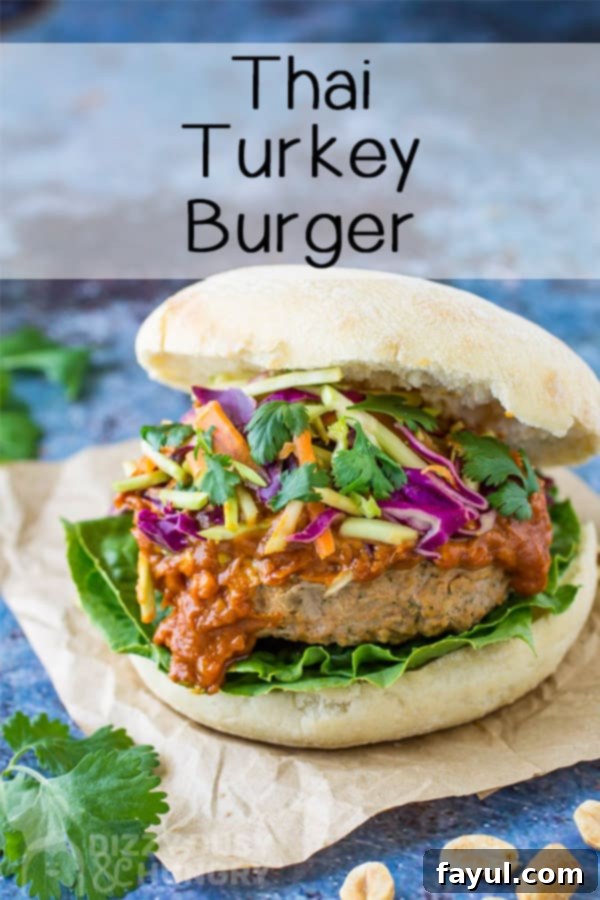 Overhead angle view of a Thai turkey burger, beautifully presented on crumpled brown paper with a delicate cilantro garnish.