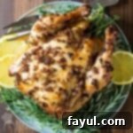 Overhead shot of a slow cooker whole chicken on a bed of fresh thyme and lemon slices, presented on a blue plate with a fork nearby.