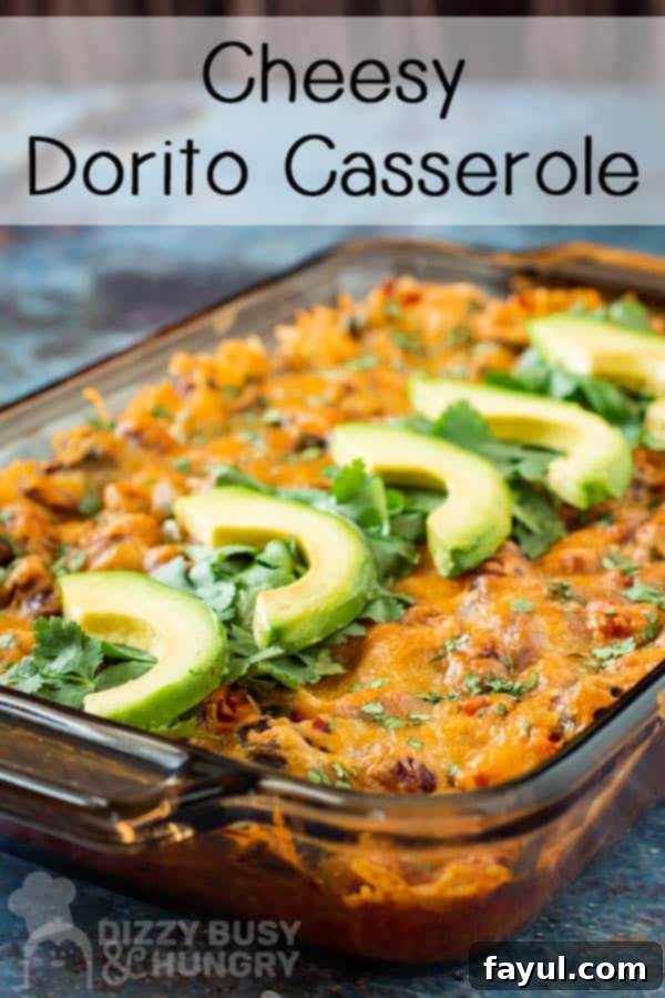 Side view of a vibrant Dorito casserole in a baking pan, generously topped with fresh chopped cilantro and slices of creamy avocado.
