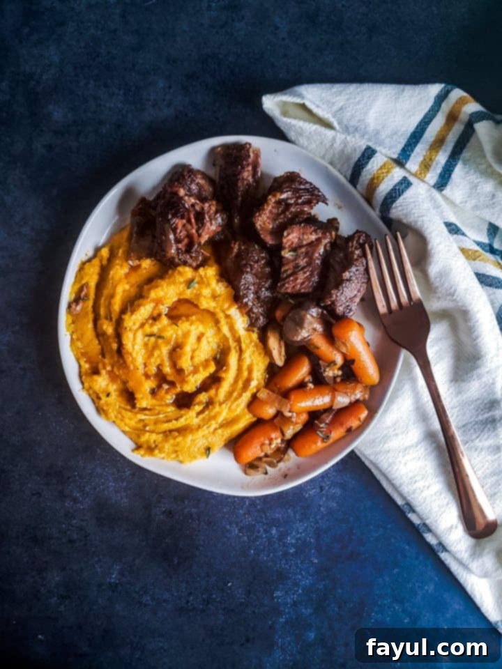 White plate with short ribs and sides on it.