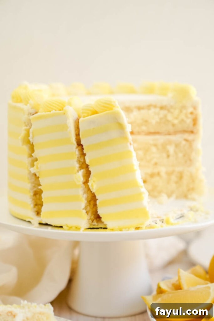 Beautifully decorated three-layer light lemon cake with cream cheese frosting and yellow stripes, perfect for summer.