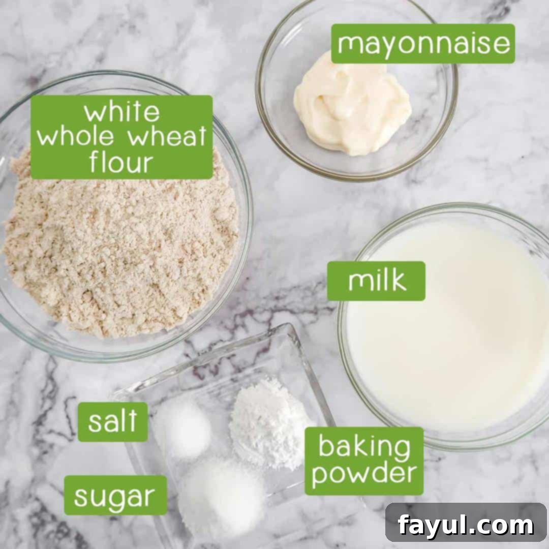 Overhead shot of drop biscuit ingredients: white whole wheat flour, mayonnaise, milk, baking powder, salt, and sugar.