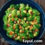 Overhead shot of garlic butter broccoli in a blue bowl on a wooden surface