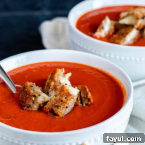 Two white bowls of soup on a blue counter.