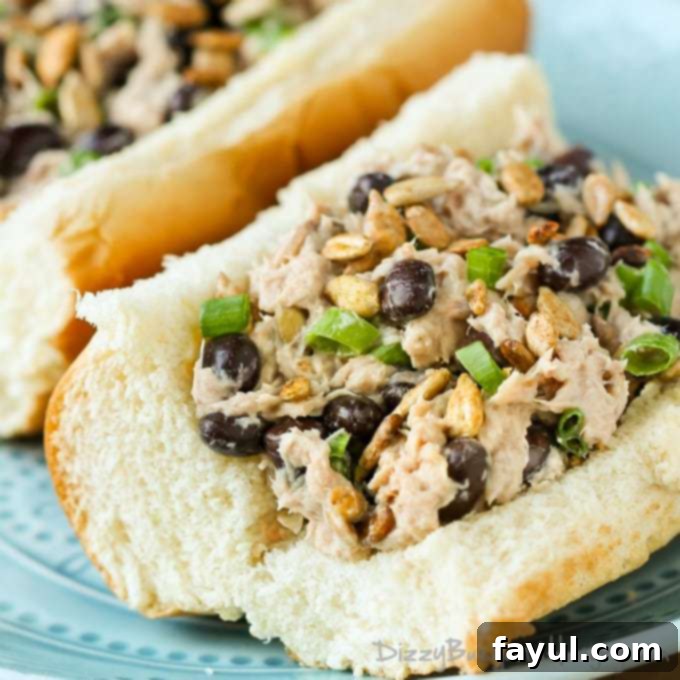 Close up view of a roll with tuna salad on a blue plate