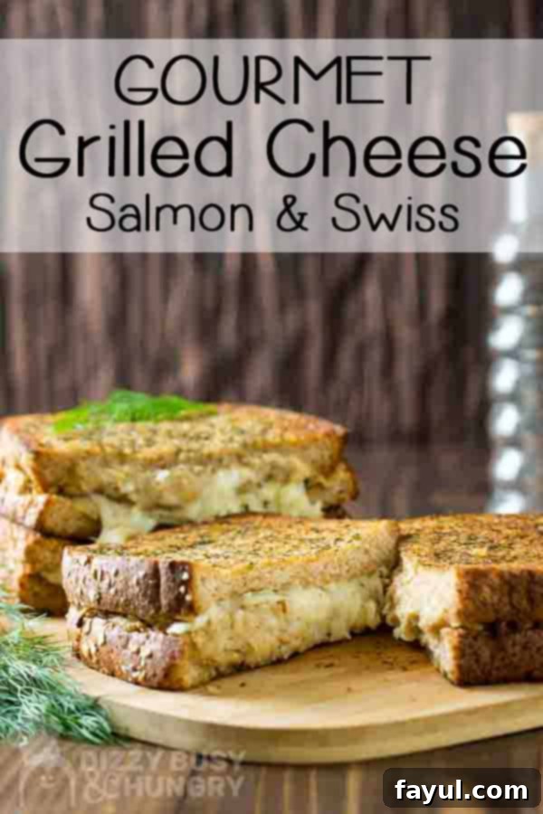 Salmon grilled cheese easy seafood recipe with an inside view of gooey cheese and crispy grilled bread on a wooden cutting board
