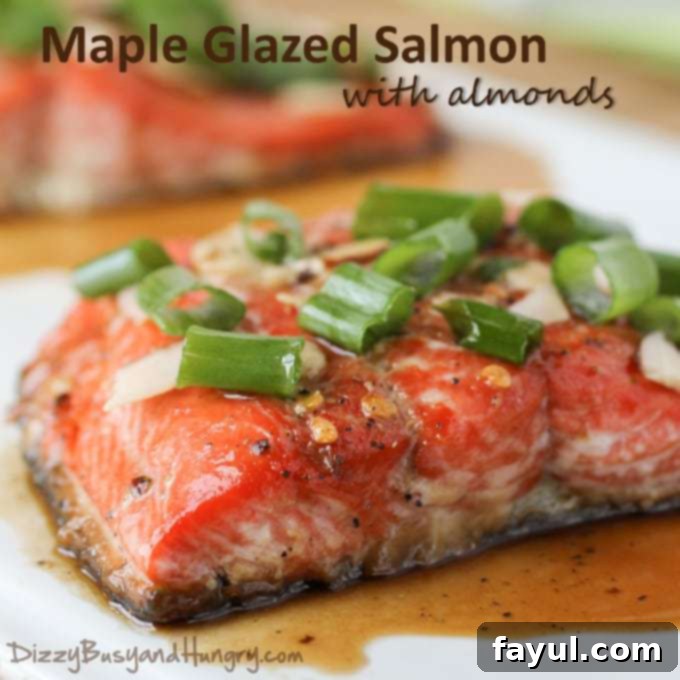 Side view of cooked salmon with maple glaze and garnished with sliced almonds and scallions.