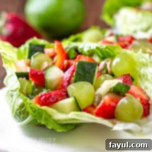 Close side view of finished veggie salad served on a white platter on a crisp green lettuce leaf.