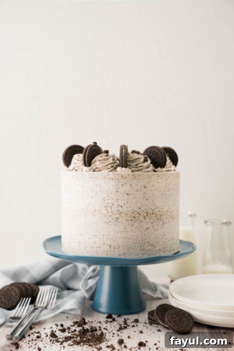 A slice of the Ultimate Cookies and Cream Cake, showing all the beautiful layers and textures, from the dark chocolate cake to the creamy white filling and speckled buttercream.