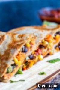 Vegetarian Quesadillas on a wooden cutting board with blue background. 