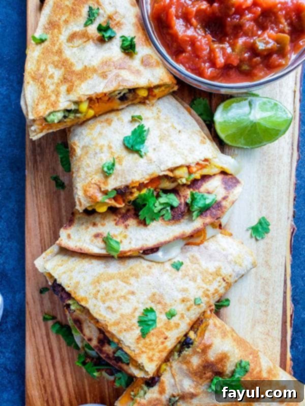 Overhead shot of sliced quesadilla on wooden cutting board.