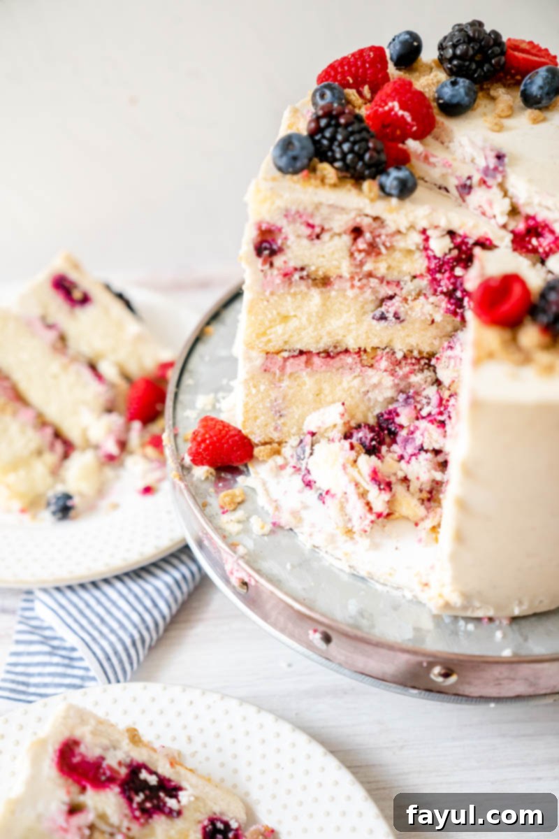 Decorating the Triple Berry Cake with the final layer of vanilla cinnamon buttercream and fresh berries.