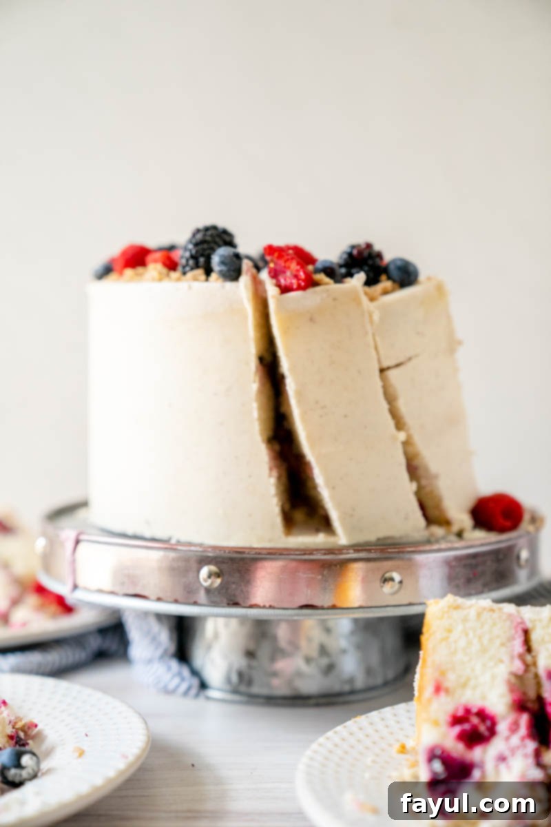 A slice of Triple Berry Cake being served, highlighting its moist texture and vibrant berry filling.