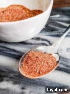 Easy Homemade Taco Seasoning on a silver spoon with more of the mix in a white bowl.
