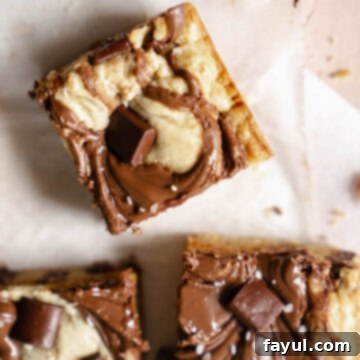 Close-up of a Nutella Blondie square with a prominent swirl, ready to eat.